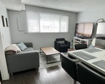 a living room with a couch and a table at Hastings Sunrise Experience in Vancouver