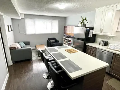 a kitchen with a kitchen island in a kitchen with a couch at Hastings Sunrise Experience in Vancouver