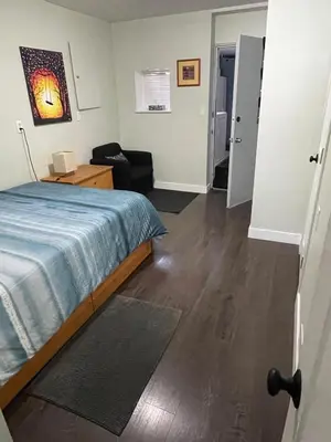 a bedroom with a bed and a desk and a chair at Hastings Sunrise Experience in Vancouver