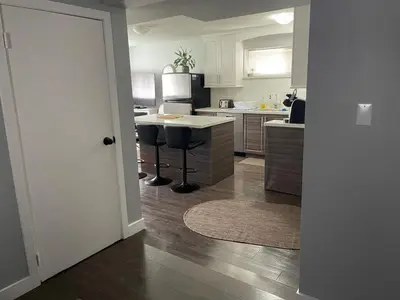 a kitchen with a counter and stools in it at Hastings Sunrise Experience in Vancouver