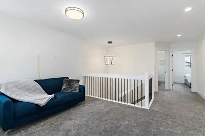 a living room with a blue couch and a bed at The Happy place - Luxurious, Cozy and Modern Home with 4 bedroom Air-condition, Netflix, Free Parking close to Airport and West Edmonton Mall in Edmonton