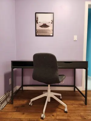 a desk with a chair in front of a wall at 2-bed house for downtown, stampede & mountains in Calgary