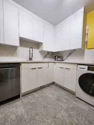a kitchen with white cabinets and a dishwasher at 2-bed house for downtown, stampede & mountains in Calgary