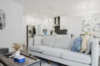 a white living room with a white couch and a table at Executive Modern Family Haven for Short Stays in Edmonton