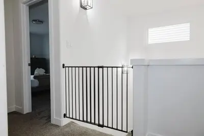 a white hallway with a gate in a room at Executive Modern Family Haven for Short Stays in Edmonton