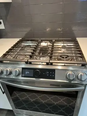 a stainless steel stove top oven in a kitchen at Executive Modern Family Haven for Short Stays in Edmonton