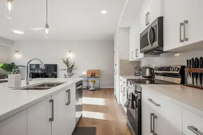 a kitchen with white cabinets and stainless steel appliances at Very Spacious Luxury Apartment with AC, 70