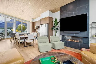 a living room with a tv and a fireplace at Scenic Views in a Luxurious Townhouse in Canmore