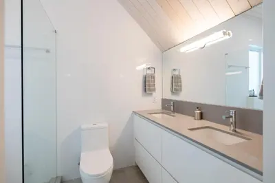 a white bathroom with a toilet and a sink at #9111 Wedgewoods in Whistler