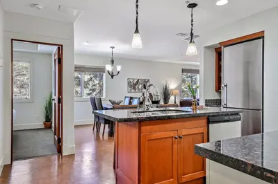 a kitchen with a counter and a dining room at Woodland Retreat 2 Bedroom in Canmore
