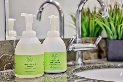 two bottles of detergent sitting on a bathroom sink at Woodland Retreat 2 Bedroom in Canmore
