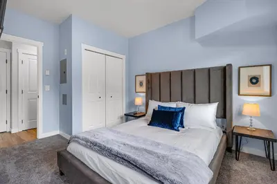 a bedroom with a large bed with blue walls at Family Gateway Outdoor Pool & Hot Tub Experience in Canmore