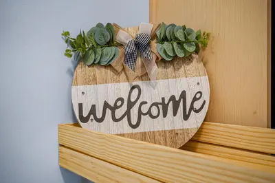 a welcome sign on a shelf with a plant at Family Gateway Outdoor Pool & Hot Tub Experience in Canmore