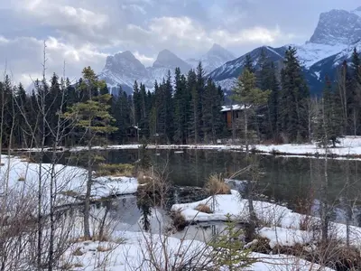 a view of a lake with snow covered mountains at Family Gateway Outdoor Pool & Hot Tub Experience in Canmore