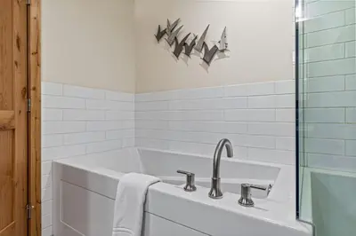 a white bathroom with a sink and a bath tub at Alpine Serenity in Canmore in Canmore