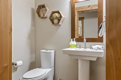 a bathroom with a toilet and a sink and a mirror at Alpine Serenity in Canmore in Canmore