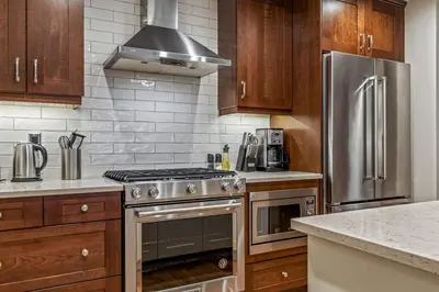 a kitchen with stainless steel appliances and wooden cabinets at Alpine Serenity in Canmore in Canmore