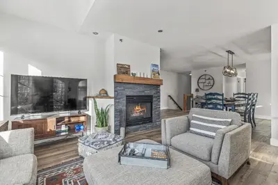 a living room with a fireplace and a tv at Spectacular Rocky Mountain Views 3BD in Canmore