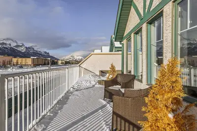 a balcony of a house with snowy mountains in the background at Spectacular Rocky Mountain Views 3BD in Canmore
