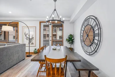 a dining room with a table and a couch at Chic Urban Sanctuary in the Heart of Down in Canmore