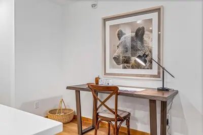a desk with a lamp and a picture of a dog at Chic Urban Sanctuary in the Heart of Down in Canmore