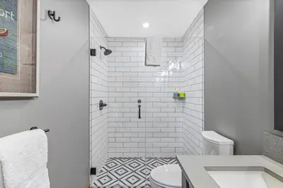 a bathroom with a shower with a toilet and a sink at Chic Urban Sanctuary in the Heart of Down in Canmore