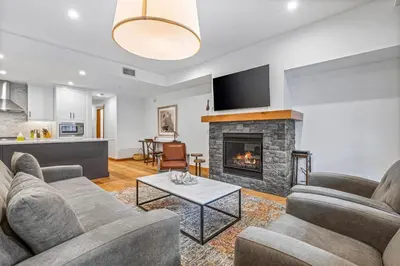 a living room with two couches and a fireplace at Chic Urban Sanctuary in the Heart of Down in Canmore