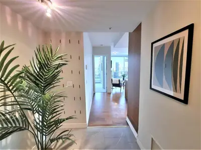a hallway of a house with a plant in it at Luxury Condo by River with City Views in Calgary
