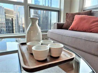 a tray with four bowls and a vase on a table at Luxury Condo by River with City Views in Calgary