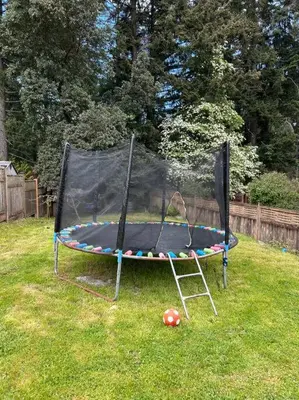 a trampoline in a yard with a soccer ball at Bright Spacious Entire Home with Kids Backyard Set in Victoria