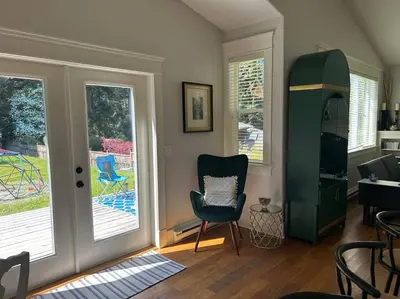 a living room with a chair and a sliding glass door at Bright Spacious Entire Home with Kids Backyard Set in Victoria