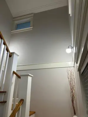 a hallway with stairs and a light on the wall at Bright Spacious Entire Home with Kids Backyard Set in Victoria
