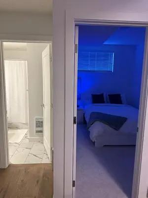 a blue bedroom with a bed and a mirror at A Cozy Private Suite in Rangeview, SE Calgary in Calgary