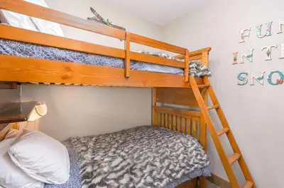 a bunk bed room with two bunk beds and a ladder at Stonegate Resort Unit B206 in Kelowna