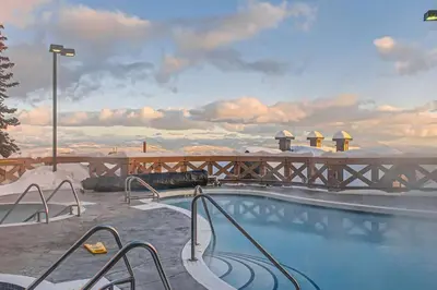 a swimming pool on top of a resort with snow at Stonegate Resort Unit B206 in Kelowna
