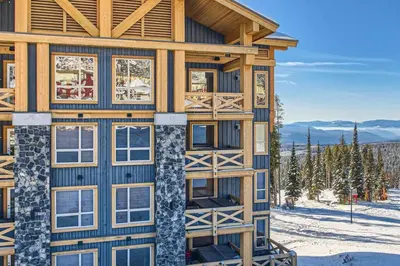 a log cabin in the snow with windows at Stonegate Resort Unit B206 in Kelowna