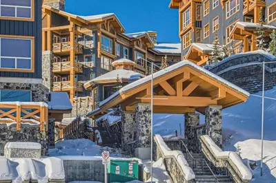 a resort in the winter with snow on the stairs at Stonegate Resort Unit B206 in Kelowna
