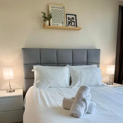 a bed with white towels on it with two lamps at Stunning Skyline Views in a Cozy and Stylish Abode in Vancouver