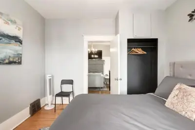 a bedroom with a large bed and a chair at Ceruleans 3BR Suite in Calgary in Calgary