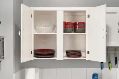 a white cabinet filled with plates and bowls at Ceruleans 3BR Suite in Calgary in Calgary