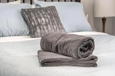 a towel sitting on top of a bed at Oakwoods 1BR Suite in Bankview in Calgary