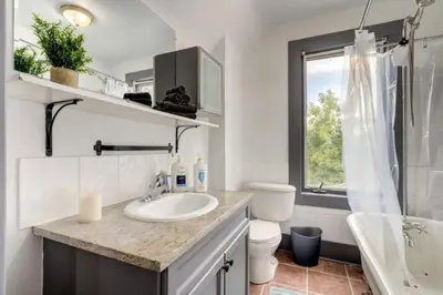 a bathroom with a sink and a toilet and a window at Oakwoods 1BR Suite in Bankview in Calgary