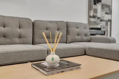 a living room with a couch and a vase on a table at Luxury Suite, Steps to Calgary DT, River, Hospital in Calgary