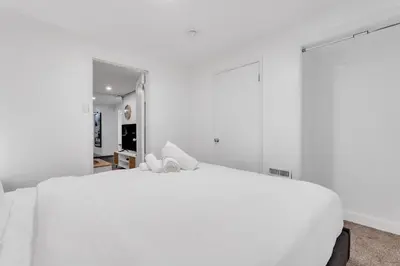 a white bedroom with a large white bed at Luxury Suite, Steps to Calgary DT, River, Hospital in Calgary