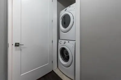 a white washer and dryer in a white room at Peaceful 2 Bedroom Suite that sleeps 4 with Free Wifi ,Free parking,easily accessible to Downtown Vancouver in Surrey