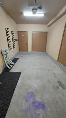 an empty room with two garage doors and a room with purple paint at Mountain Escape for Ski and Golf Enthusiasts in Kimberley