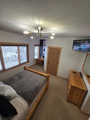 a bedroom with a bed and a table in it at Mountain Escape for Ski and Golf Enthusiasts in Kimberley