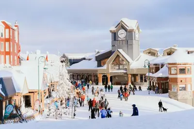 a group of people walking around a town in the snow at The Dorm Ski-In Ski-Out Studio, Pool and Gym in Big White