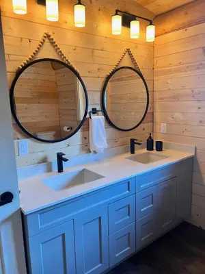 a bathroom with two sinks and two mirrors at Douglas Fir Retreat, Mtn Views and Expansive Deck in Sunshine Valley