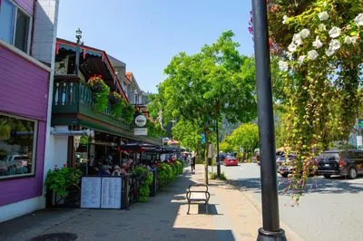 a city street with people sitting outside a restaurant at The Luna, New Penthouse w Patio, Lake and Mtn Views in Harrison Hot Springs